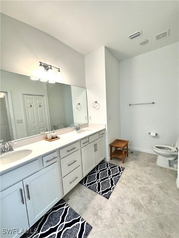 Bathroom with tile flooring, toilet, and double si