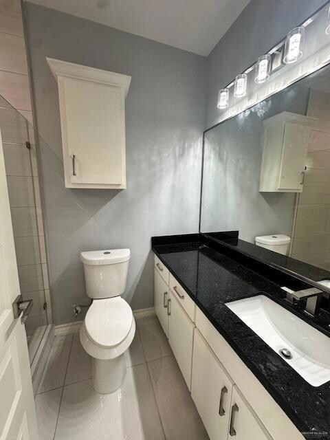 Full bathroom featuring vanity, a stall shower, and tile patterned flooring