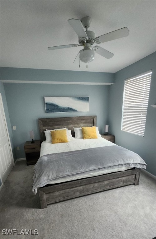 Bedroom with a ceiling fan, baseboards, and carpet