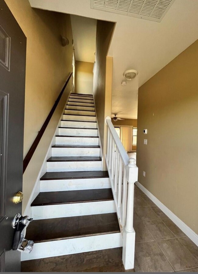 Staircase featuring tile patterned floors and bas