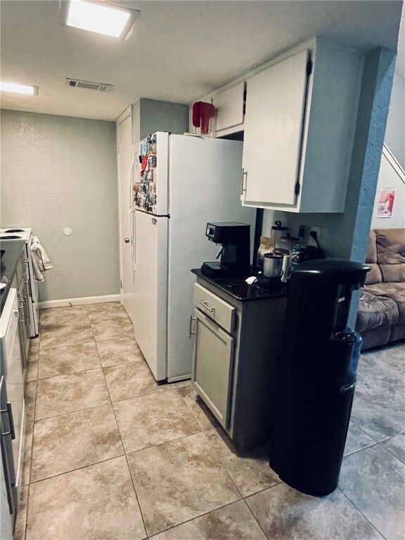 Kitchen featuring white appliances, light tile pat