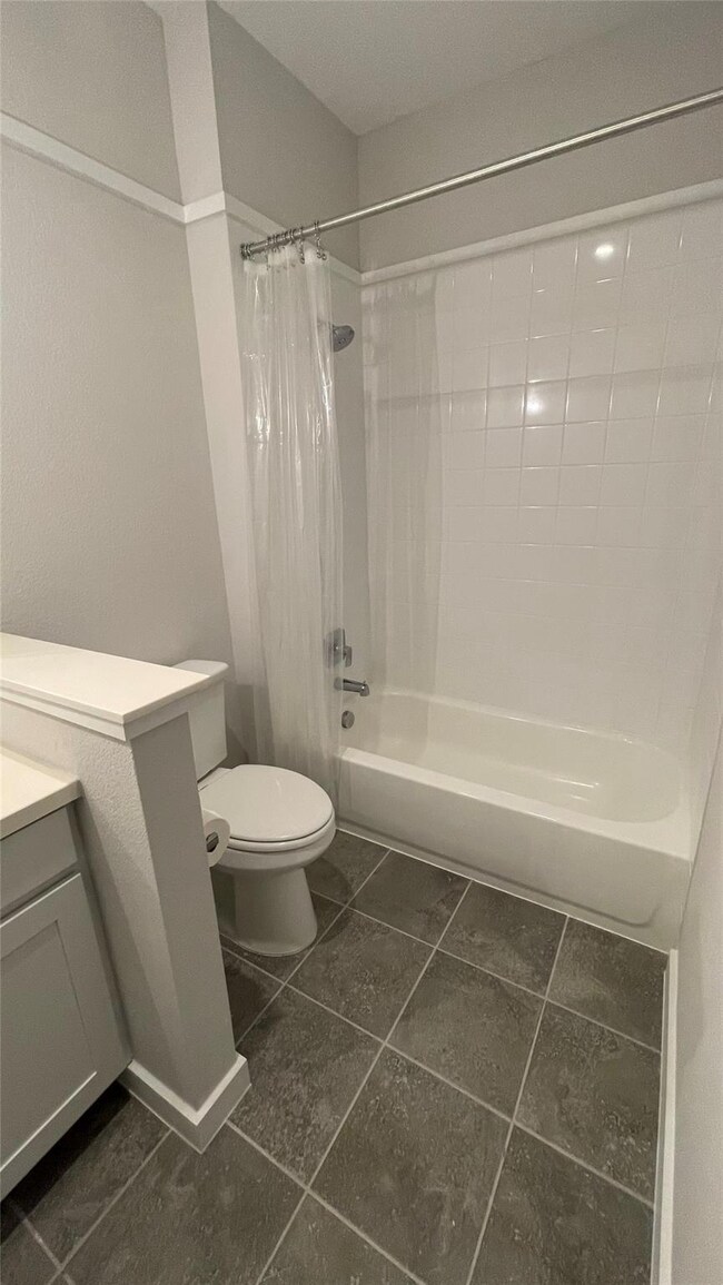 Full bathroom with toilet, shower / tub combo, an