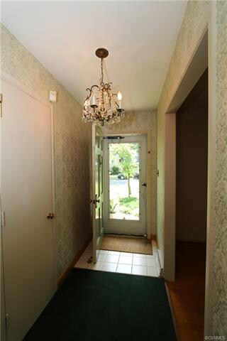 Foyer features a chandelier, guest closet and oak 
