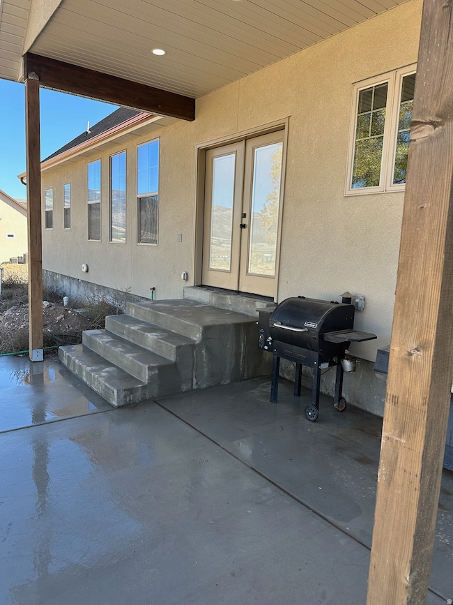 View of patio with french doors and a grill