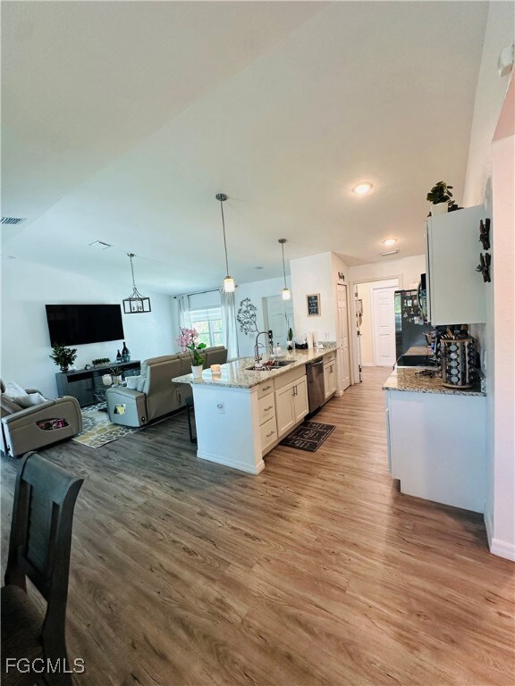 Kitchen with wood finished floors, a peninsula, op