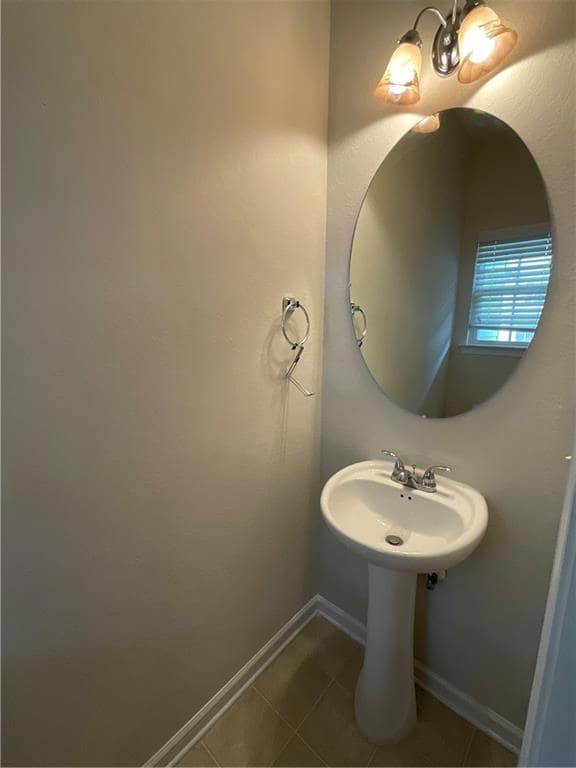 Bathroom with tile patterned floors and baseboards