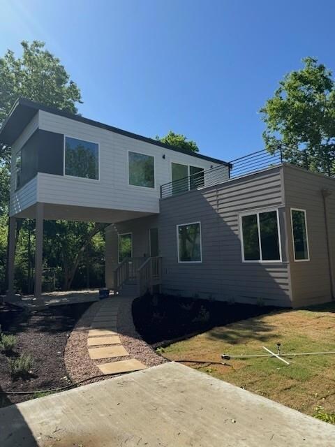 Contemporary home with a front lawn and a balcony