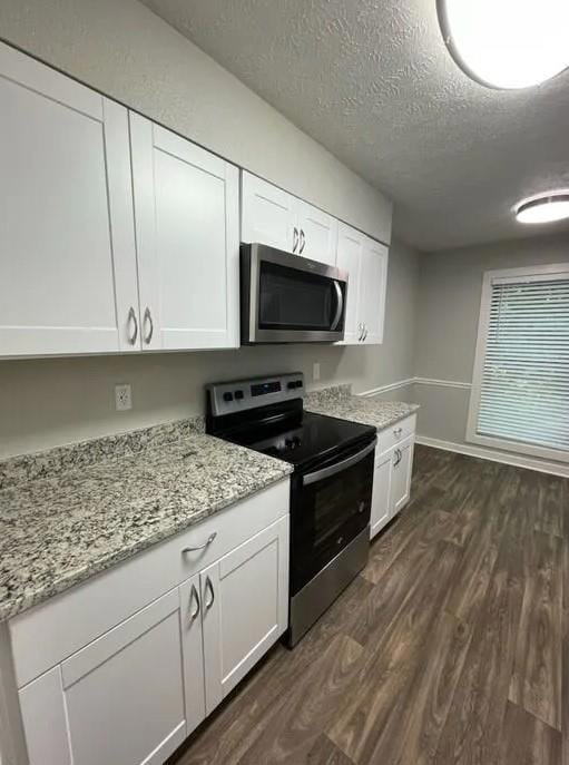Kitchen featuring white cabinetry, a textured ceil