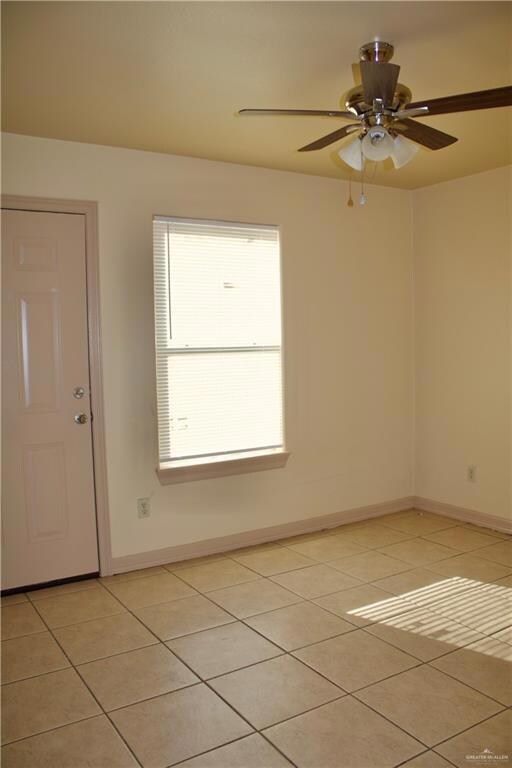 Unfurnished room with baseboards, a ceiling fan, and light tile patterned floors