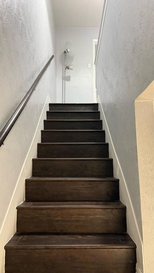 Stairway featuring a textured wall