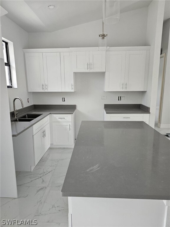 Kitchen featuring pendant lighting, white cabinetr