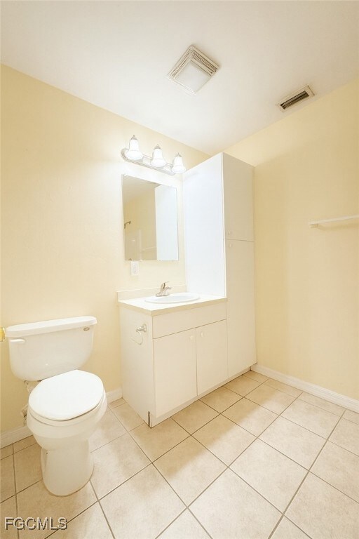 Half bath with vanity and light tile patterned flooring