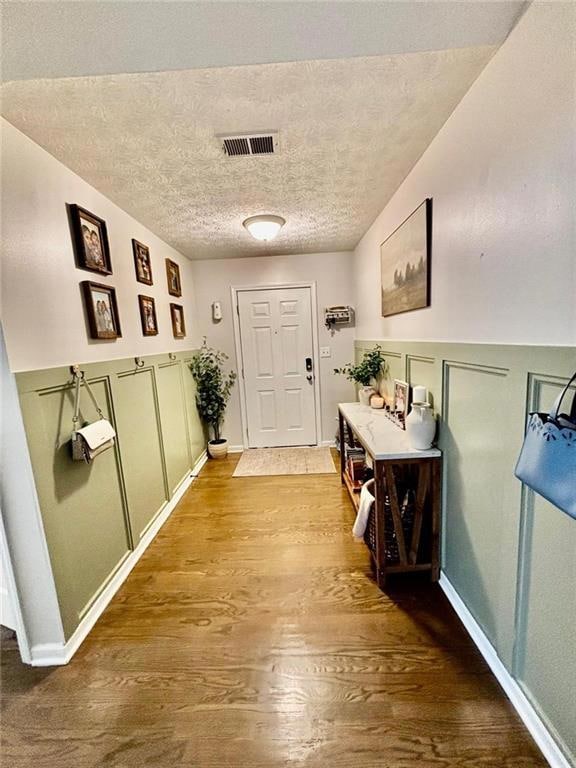 Entrance foyer with wood finished floors, a textur
