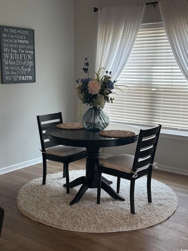 Dining area with baseboards and wood finished floo