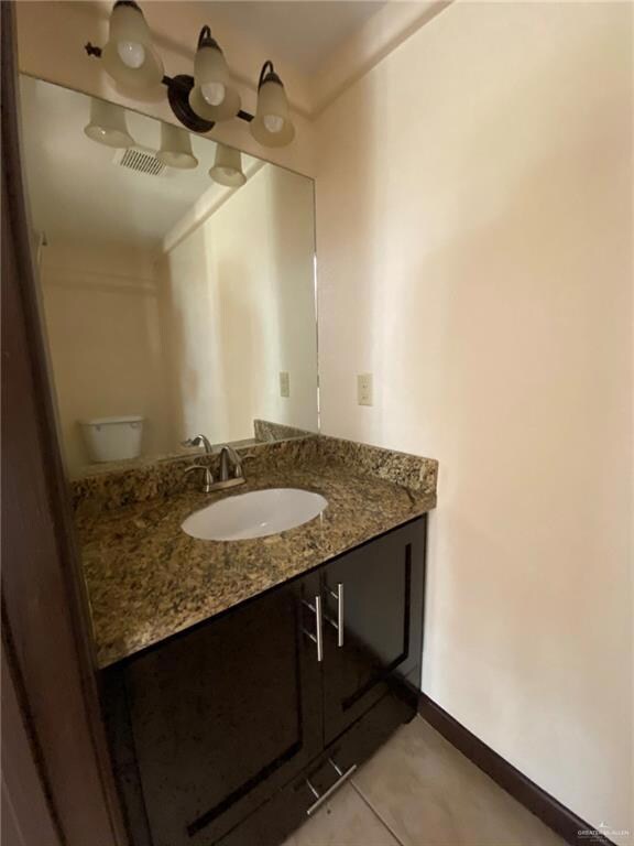 Kitchen featuring ceiling fan, kitchen peninsula, stainless steel fridge, light tile flooring, and decorative light fixtures