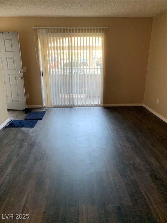 Unfurnished room featuring dark wood-style floors,