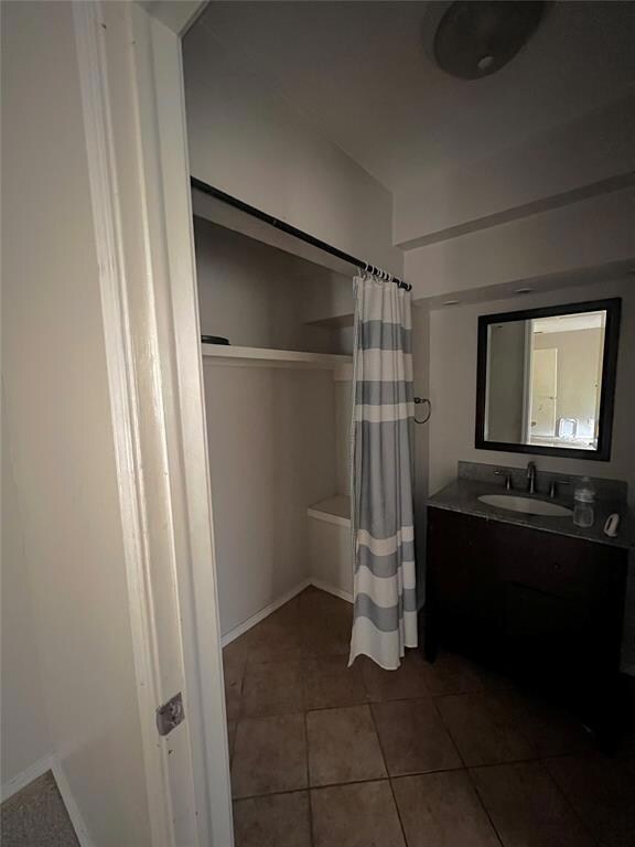 Bathroom with vanity, tile flooring, and shower / 