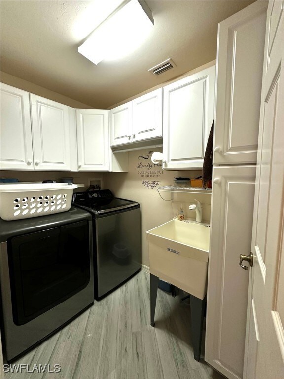 Washroom with washer and dryer, light hardwood / w