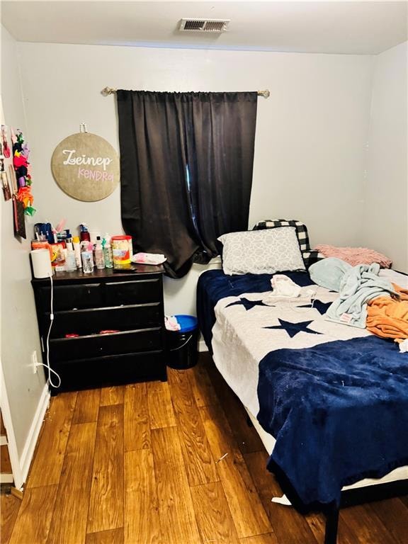 Bedroom with hardwood / wood-style flooring and baseboards