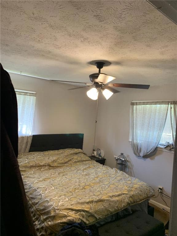 Bedroom featuring ceiling fan and a textured ceili