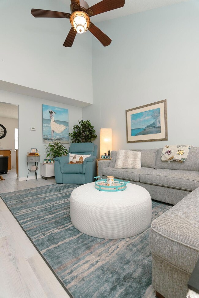 Living room with a towering ceiling, hardwood / wo