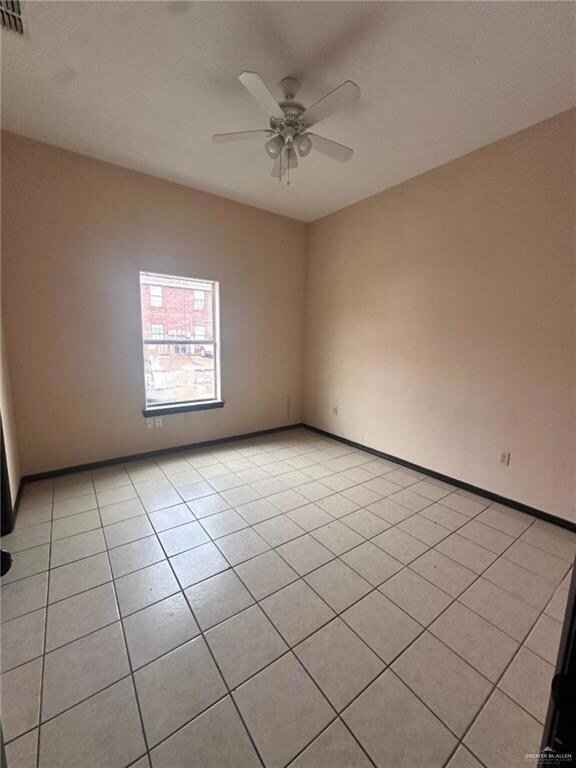 Spare room with ceiling fan and light tile patterned floors