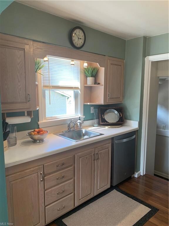 Kitchen with paneled dishwasher, laminate flooring, and light countertops