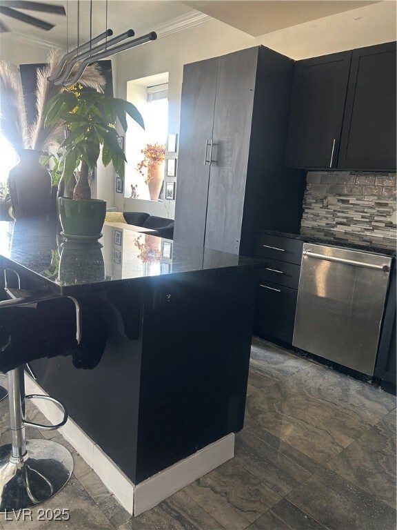 Kitchen with dark countertops, crown molding, dark