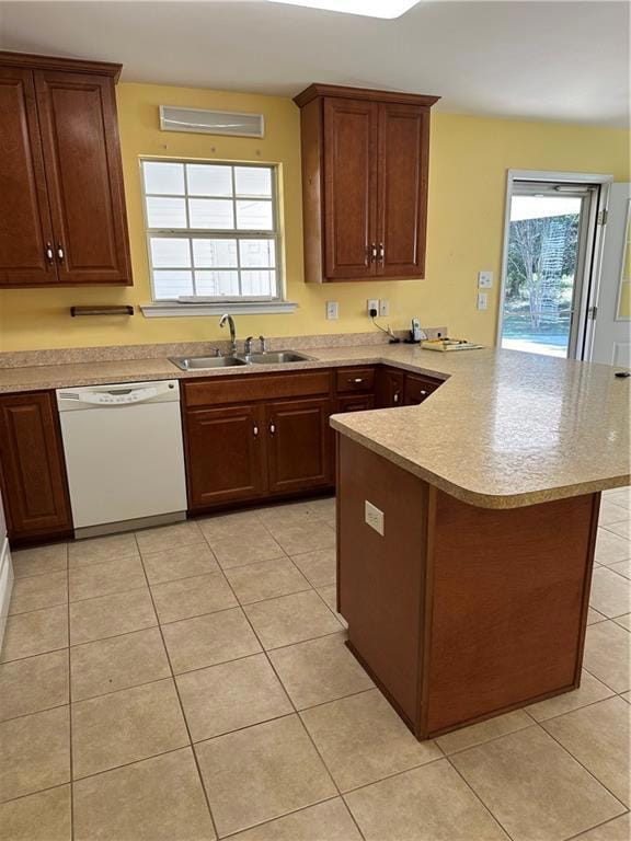 Kitchen with a peninsula, dishwasher, light tile patterned floors, and light countertops