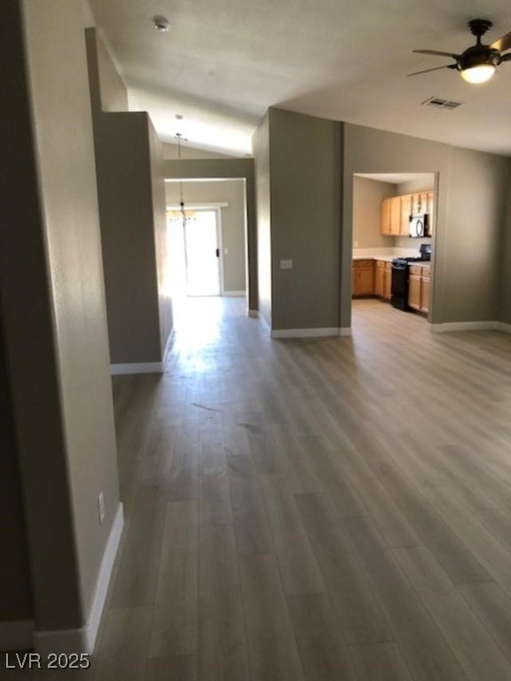 Living room featuring vaulted ceiling, ceiling fan