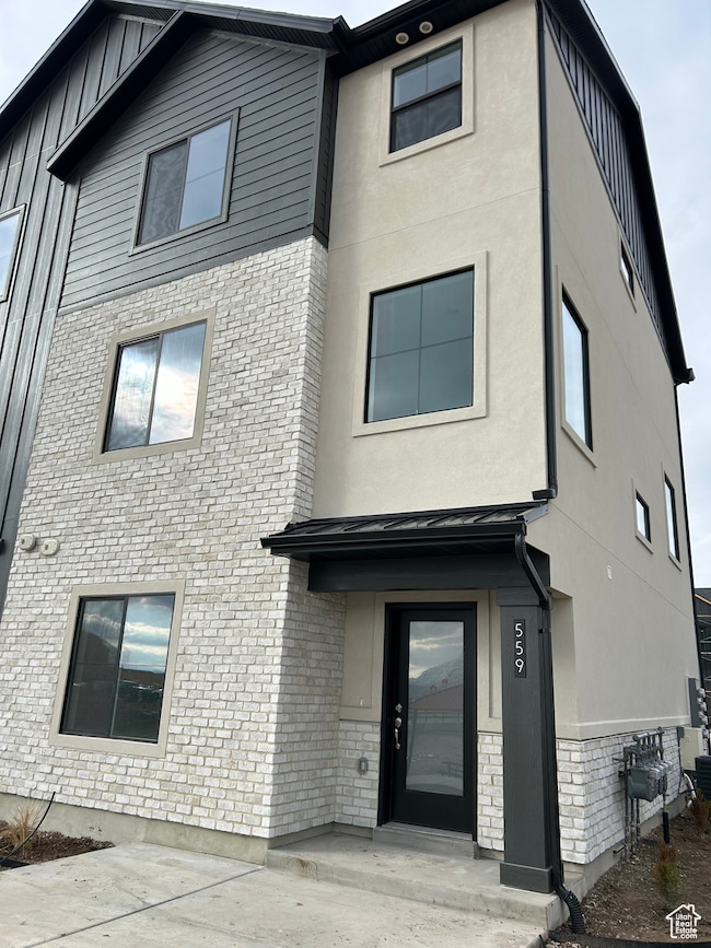 View of front of property featuring stone siding and board and batten siding