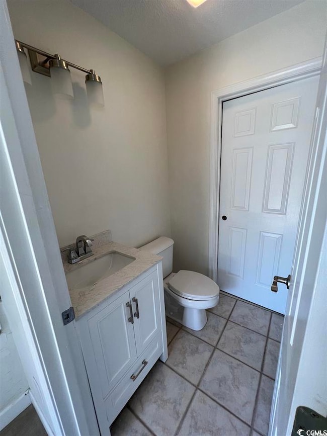 Bathroom with vanity, a textured ceiling, and light tile patterned flooring