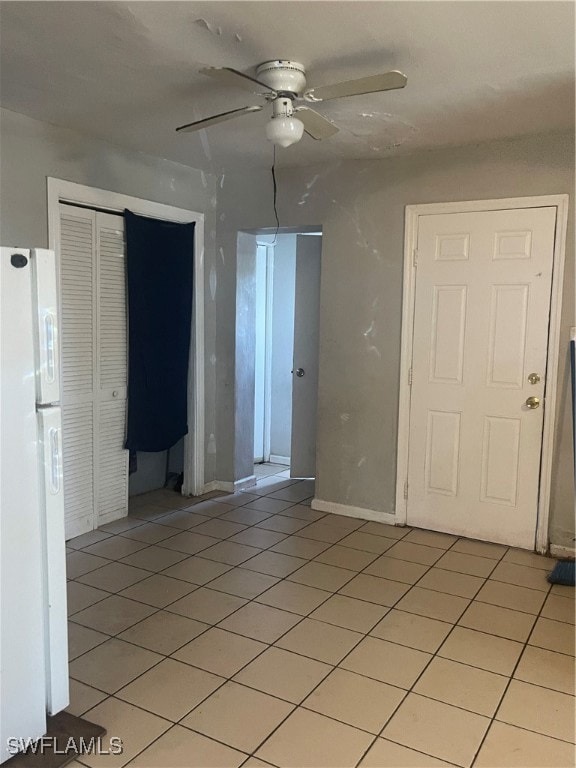 Unfurnished room with ceiling fan and light tile p