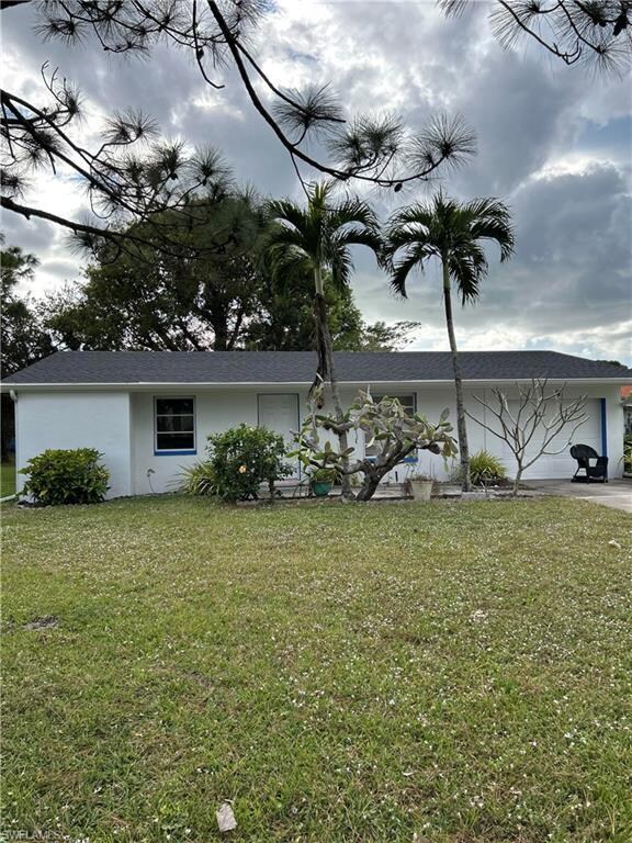 View of side of home featuring a garage and a yard