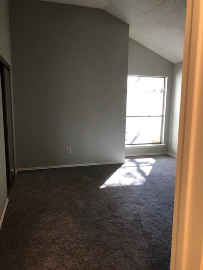 Primary bedroom with vaulted ceiling