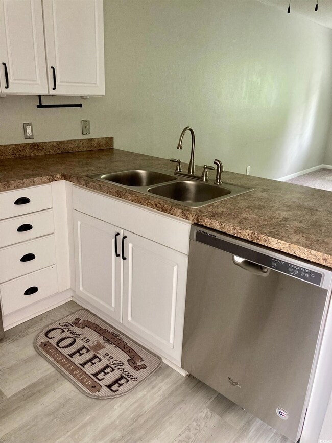 Kitchen with dishwasher, sink, light hardwood / wo