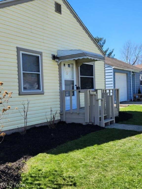 View of front of property with a garage and a front lawn