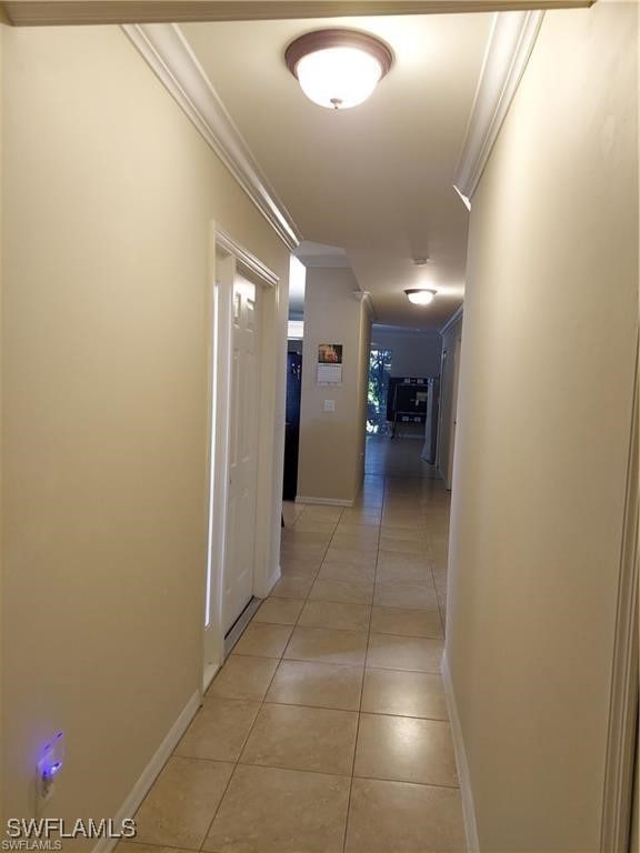Hall with crown molding and light tile patterned f