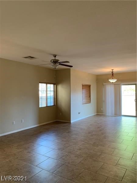 Spare room featuring baseboards and ceiling fan