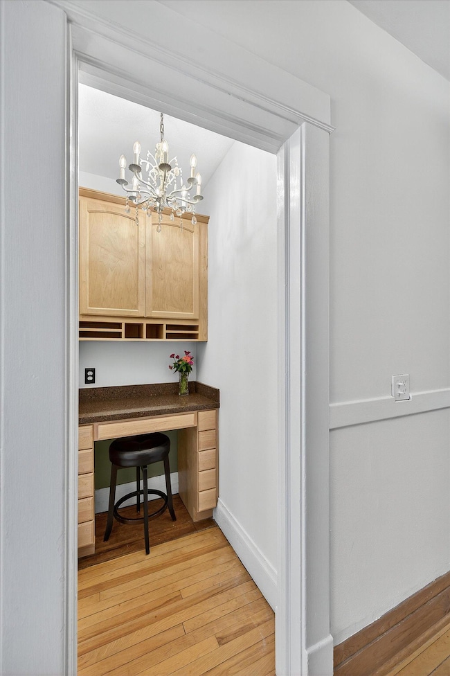 New work station with custom cabinets and desk accented by a vintage chandelier.