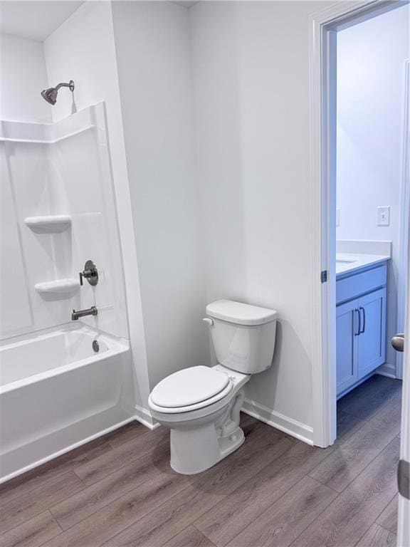 Bathroom featuring dark wood-type flooring, shower / bathtub combination, and vanity