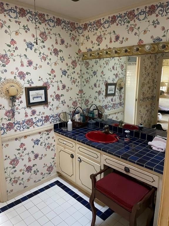 Kitchen featuring wallpapered walls, tile counters