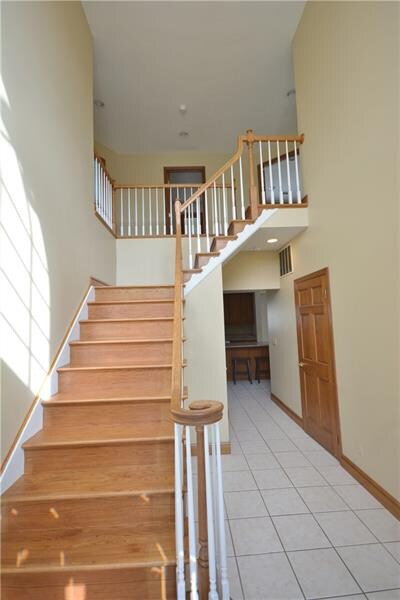 Welcoming entry with ceramic tile floor and oak wo