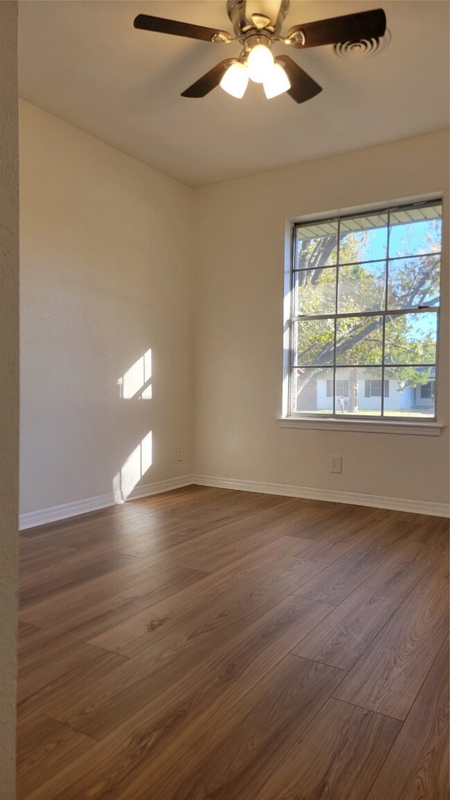 Spare room with dark hardwood / wood-style flooring and ceiling fan