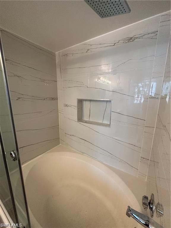 Full bathroom featuring a shower with shower door and a tub