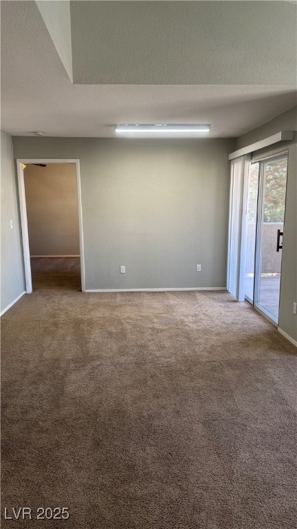 Carpeted spare room with baseboards and a textured