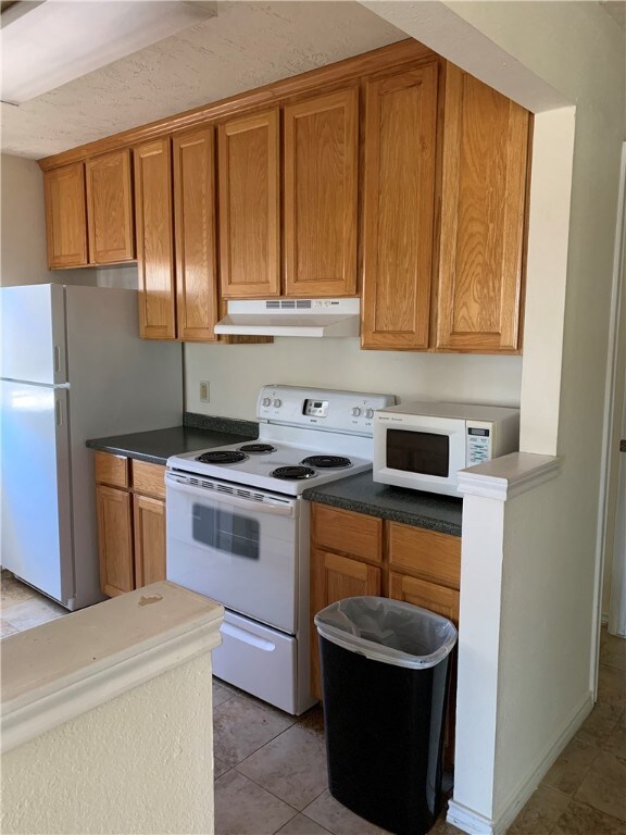 Kitchen with white appliances, under cabinet range