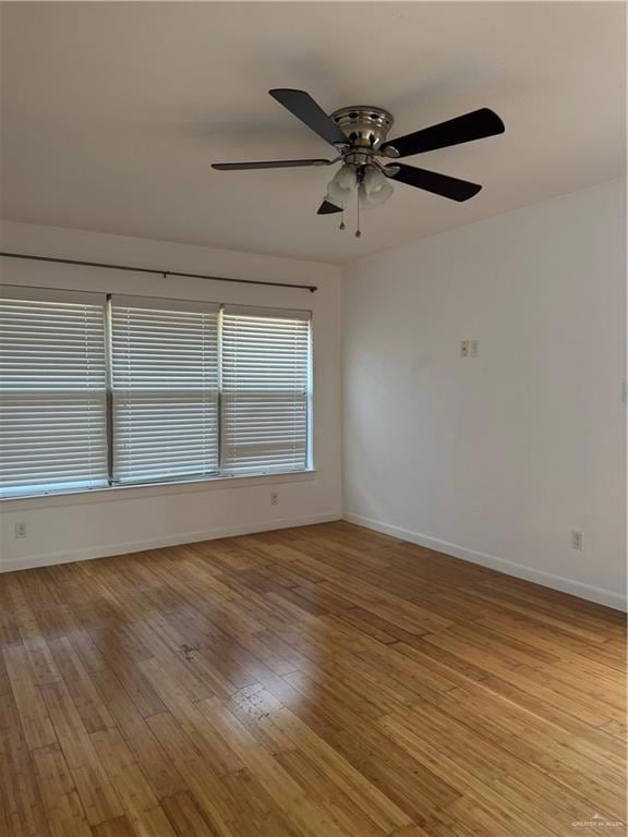 Empty room with baseboards, light wood finished floors, and ceiling fan