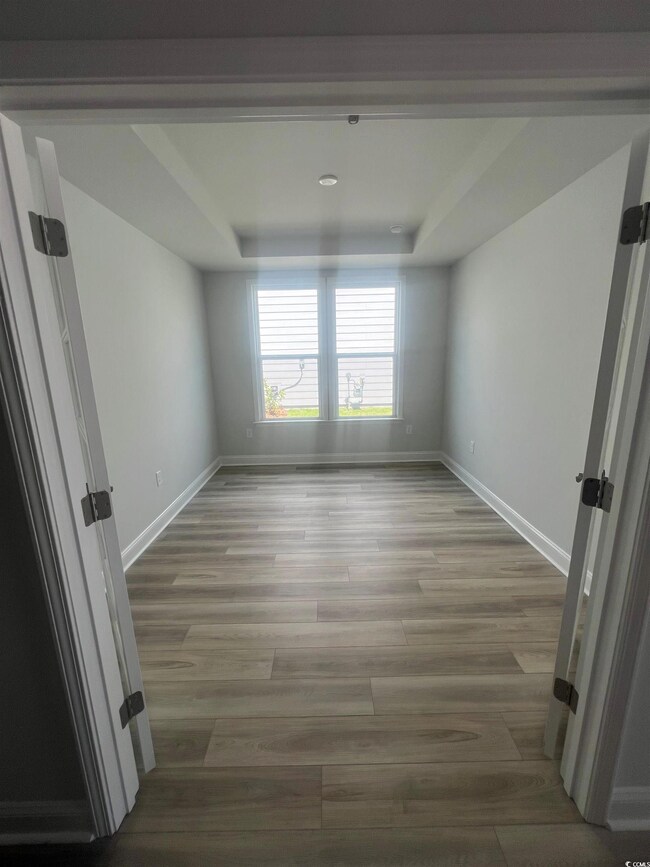 Empty room featuring hardwood / wood-style floorin