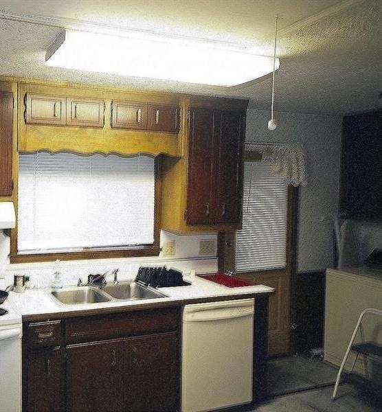 Kitchen with light countertops, a sink, exhaust ho